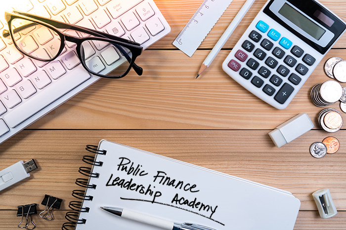 picture of keyboard, calculator, and notepad that has "Public Finance Leadership Academy" written on it.