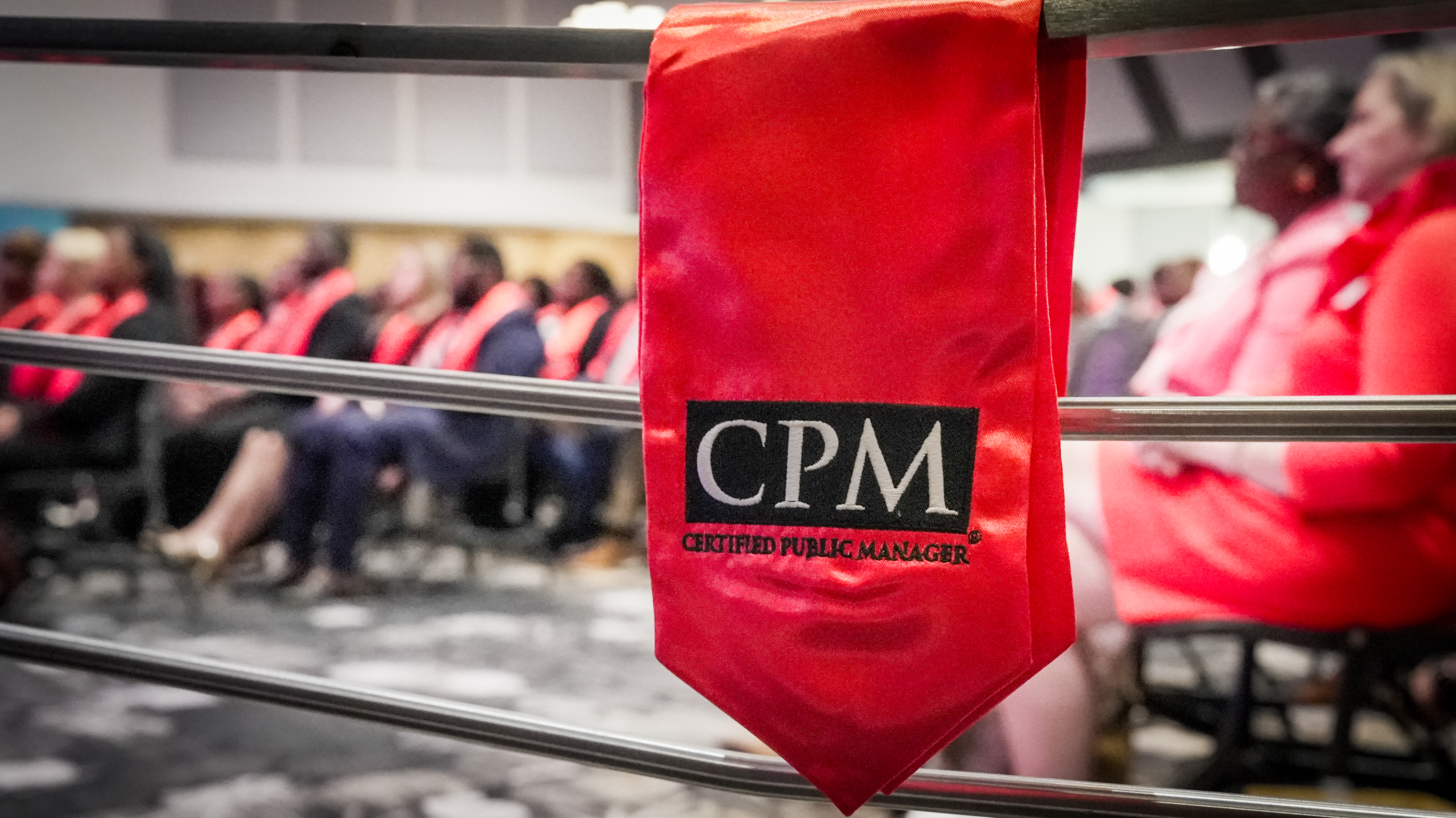 Graduates of CPM with COM stole in foreground.