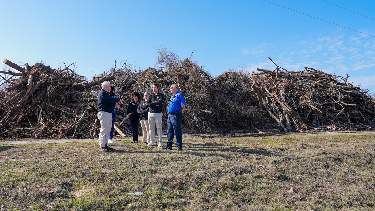 PROPEL Rural Scholars tour a storm debris collection site in Emanuel County with public safety personnel. (Photo by Sara Ingram)