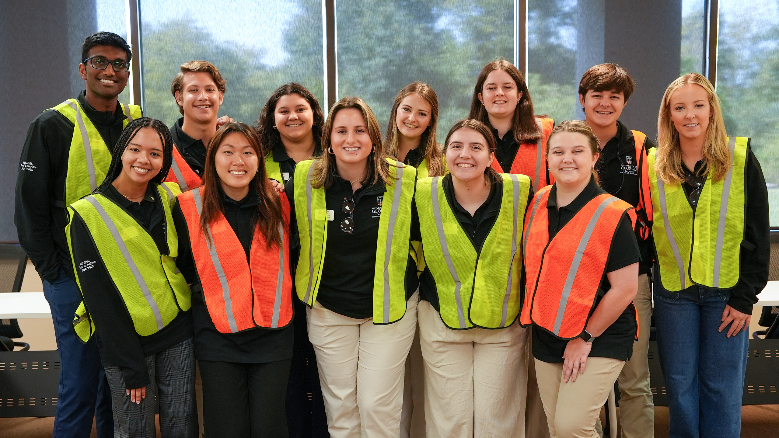 Scholars with vests stand for a group photo
