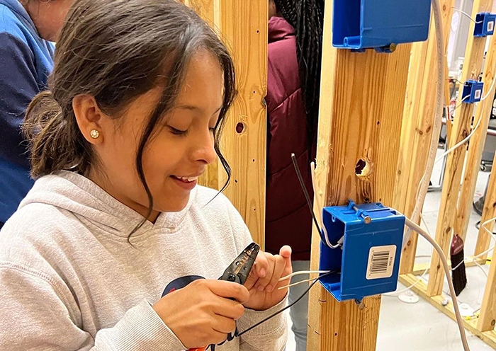 Student participating in “This Girl Can” program practices wiring a light switch as part of non-traditional occupational training.